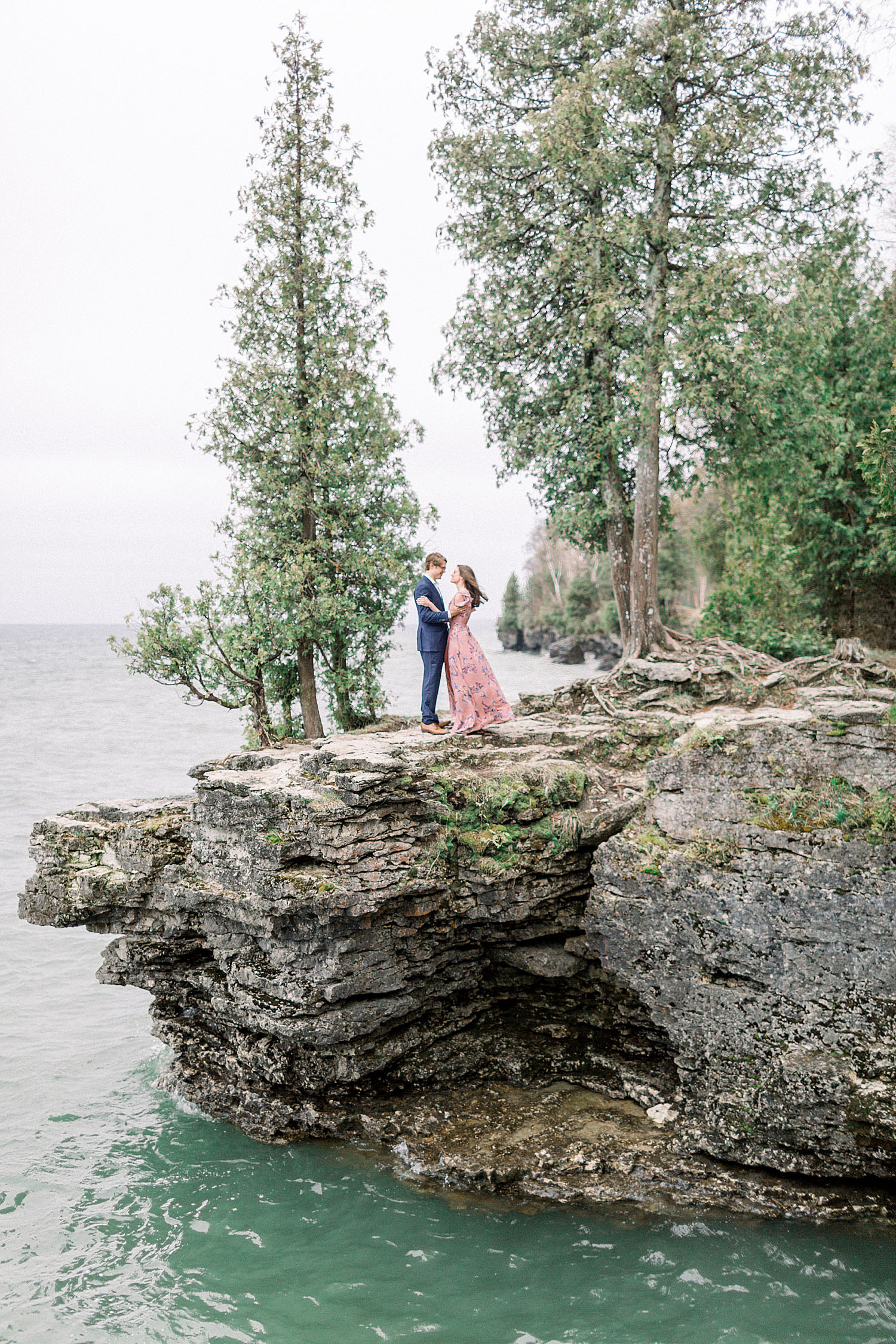 A couple embracing at Cave Point on the bluff. Door County Travel Guide