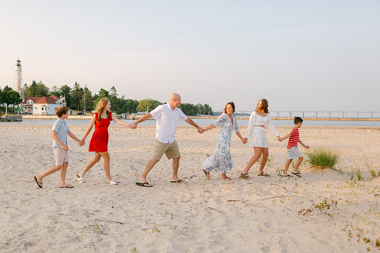 Family walking hand in hand on the beach at a Sturgeon Bay Canal Light Family Session
