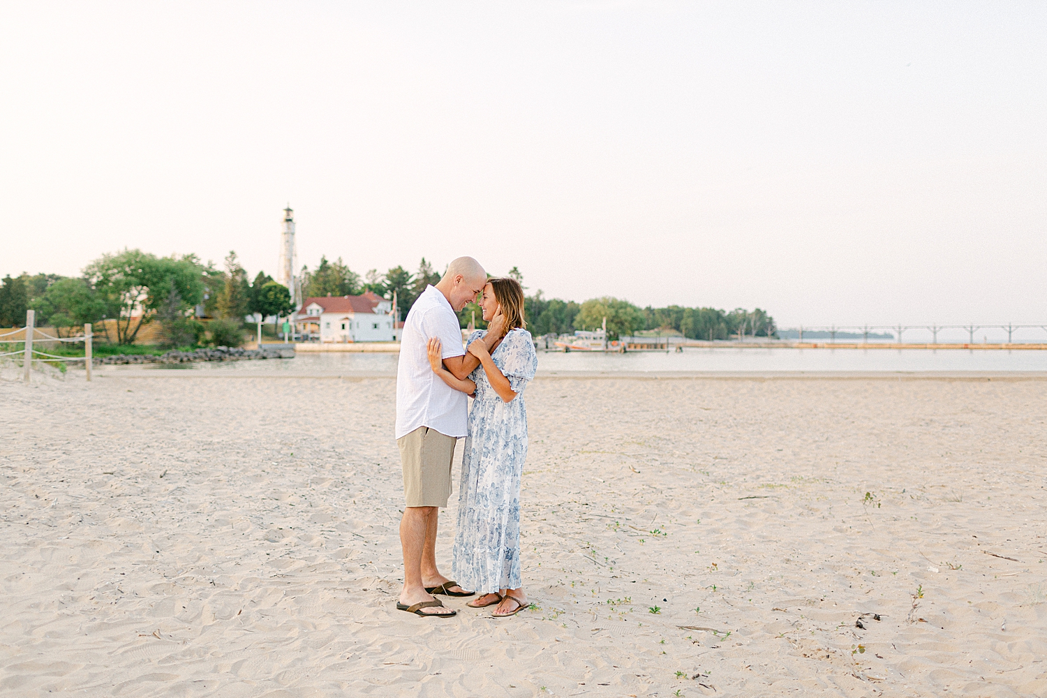 parents looking into eachothers eyes posing on the beach in Door County for a Sturgeon Bay Canal Light Family Session