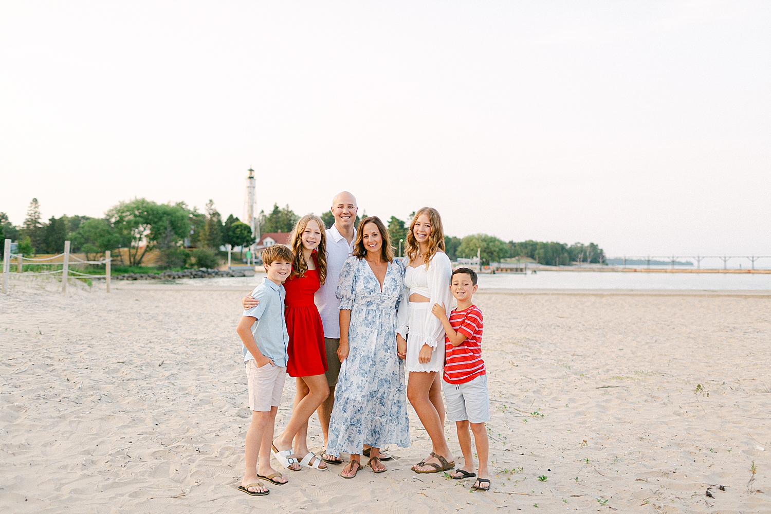 A sweet family posing on the beach for a photo during their Sturgeon Bay Canal Light Family Session