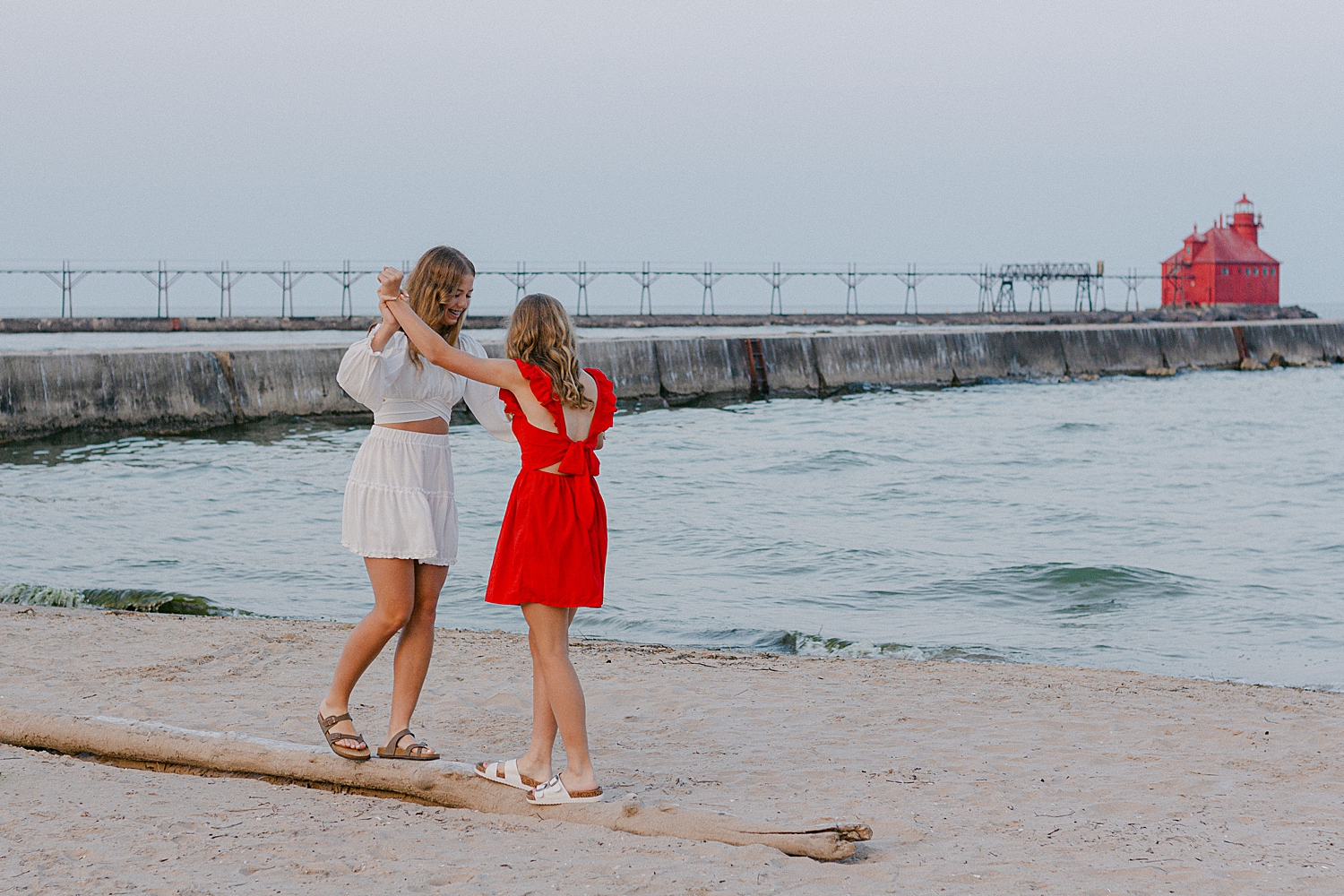 Sisters playing on the beach at their Sturgeon Bay Canal Light Family Session