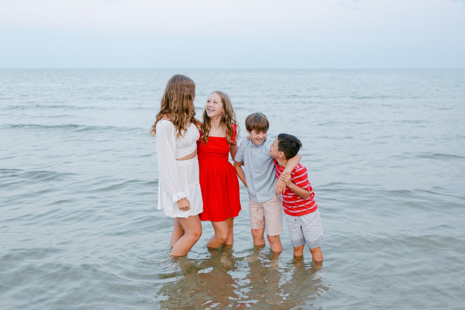 sibling photo playing in the water at the beach at their Sturgeon Bay Canal Light Family Session