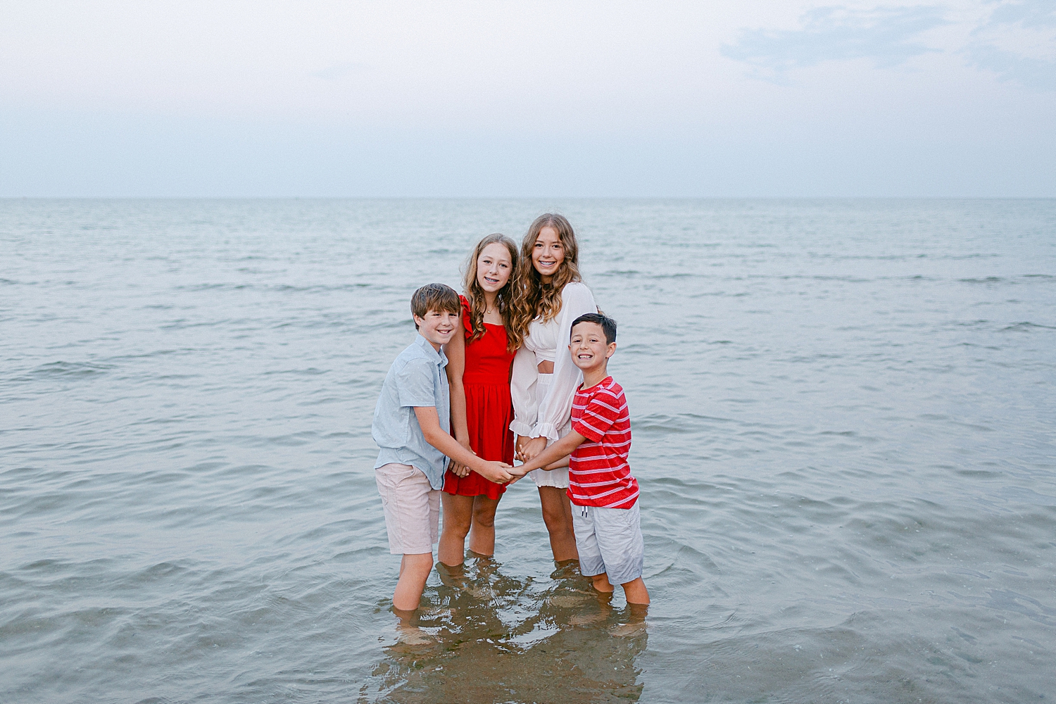 Siblings playing in the water at the beach at their Sturgeon Bay Canal Light Family Session