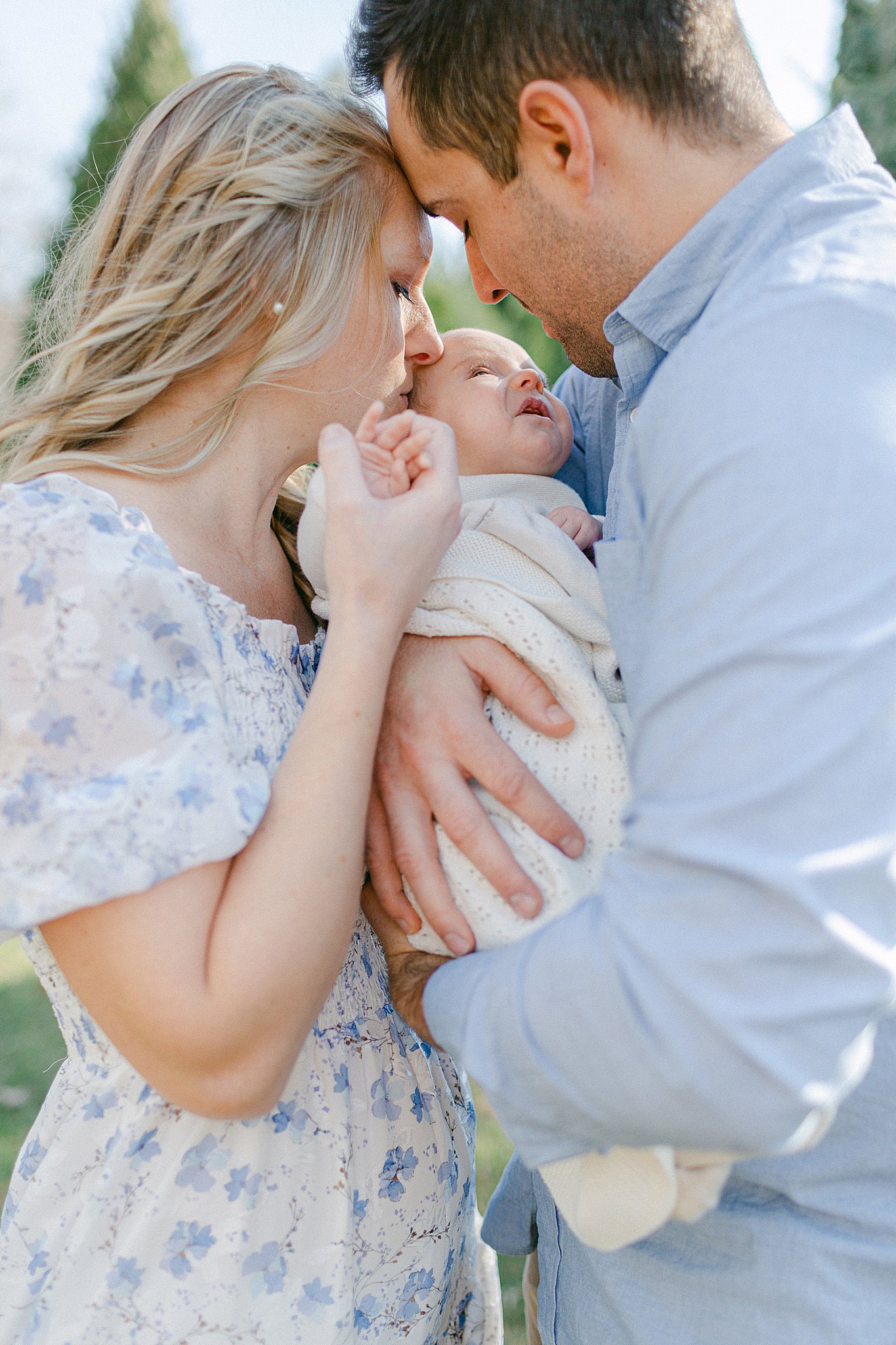 Mom and Dad kissing baby girl at a Newborn Session in Green Bay