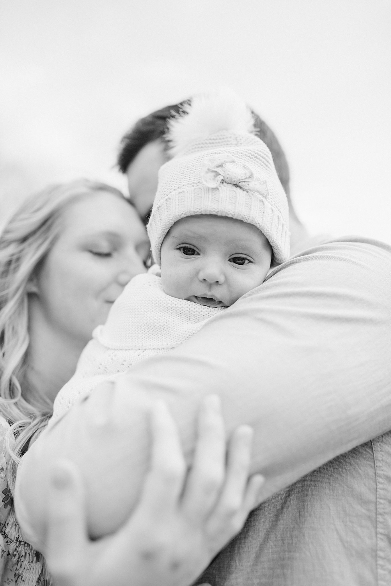 baby girl being held by Mom & Dad at a Newborn Session in Green Bay