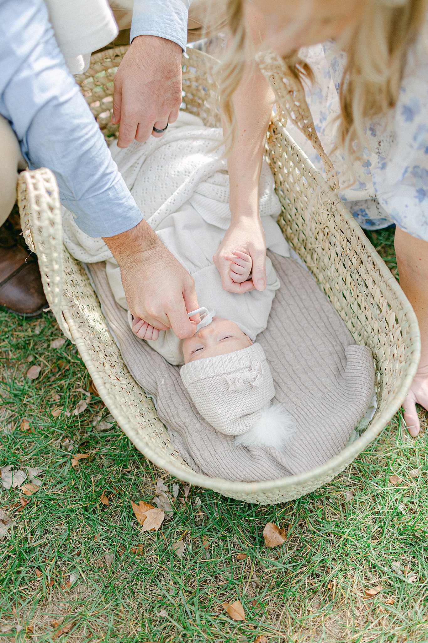 Mom & Dad soothing baby girl in a moses basket at a Newborn Session in Green Bay